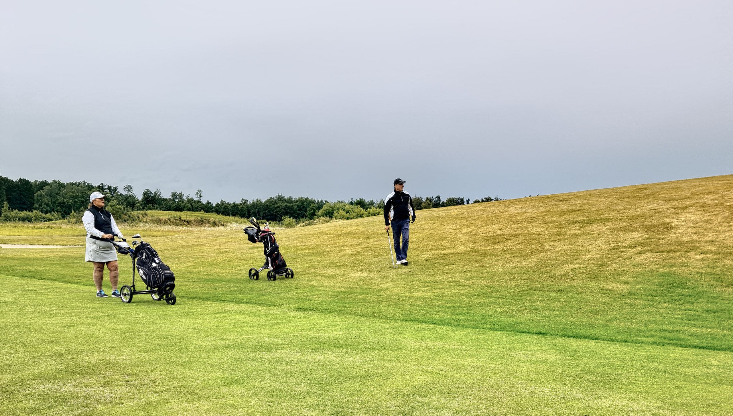 Two golfers in easy conversation walking the fairway together on a corporate day