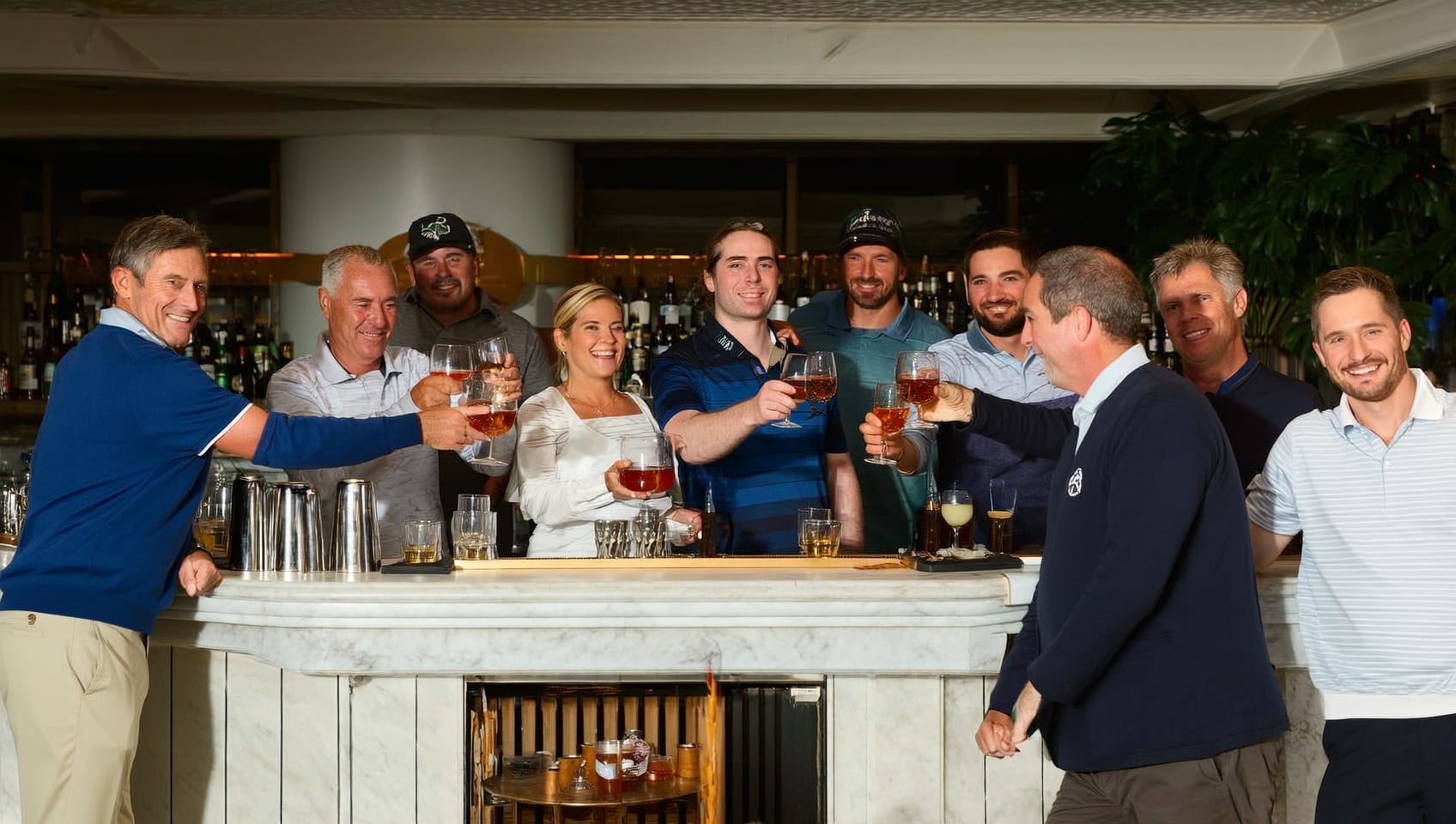 Friends toasting at a clubhouse bar after a round, the marble counter catching the evening light