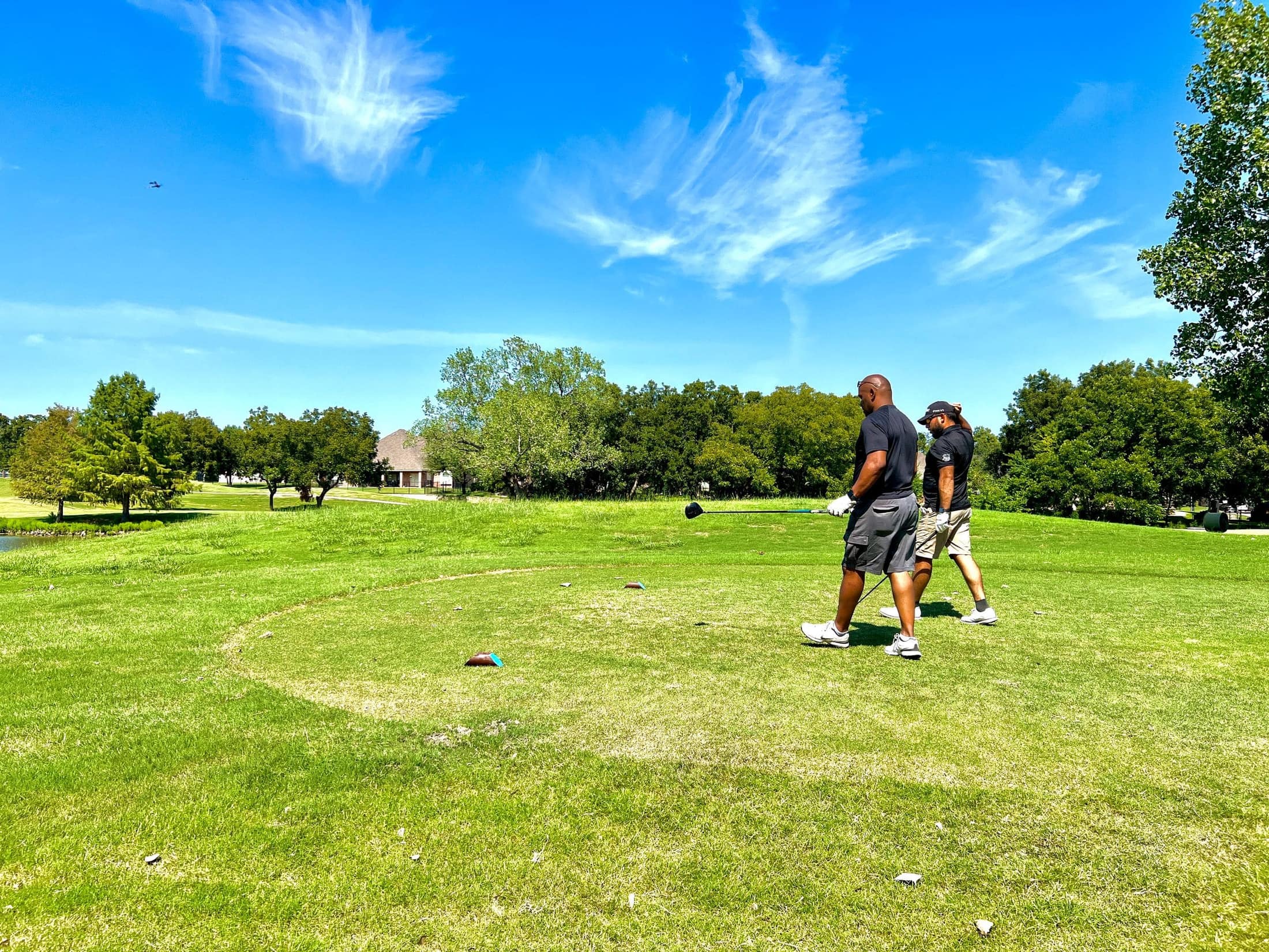 A group of golfers walking a windswept coastal links course together, bags over their shoulders