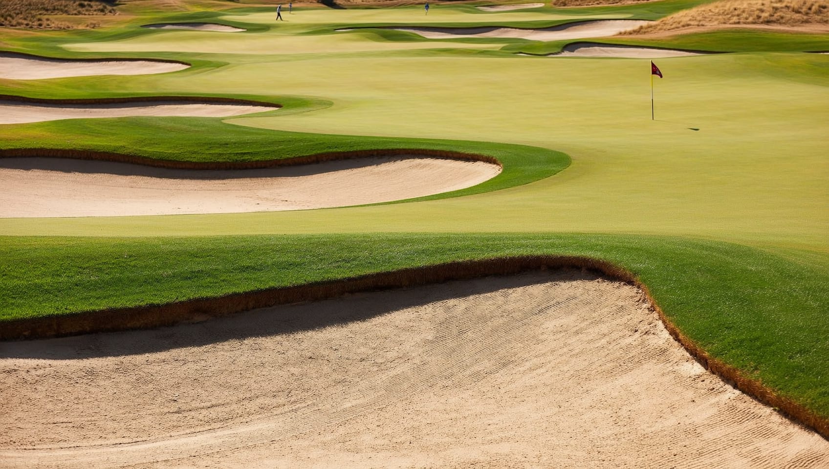 A golfer completing a full swing on a sunlit fairway with distant hills and clear sky beyond